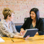 Two women meet to discuss a life insurance policy in Illinois