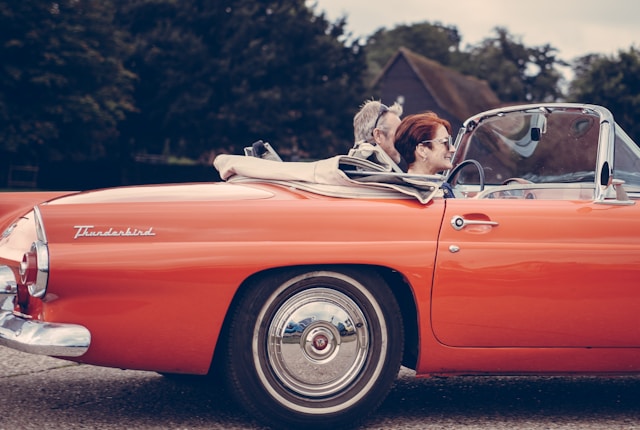 A couple drives a vintage car for which they should reevaluate their insurance policy through the David Nelson Agency